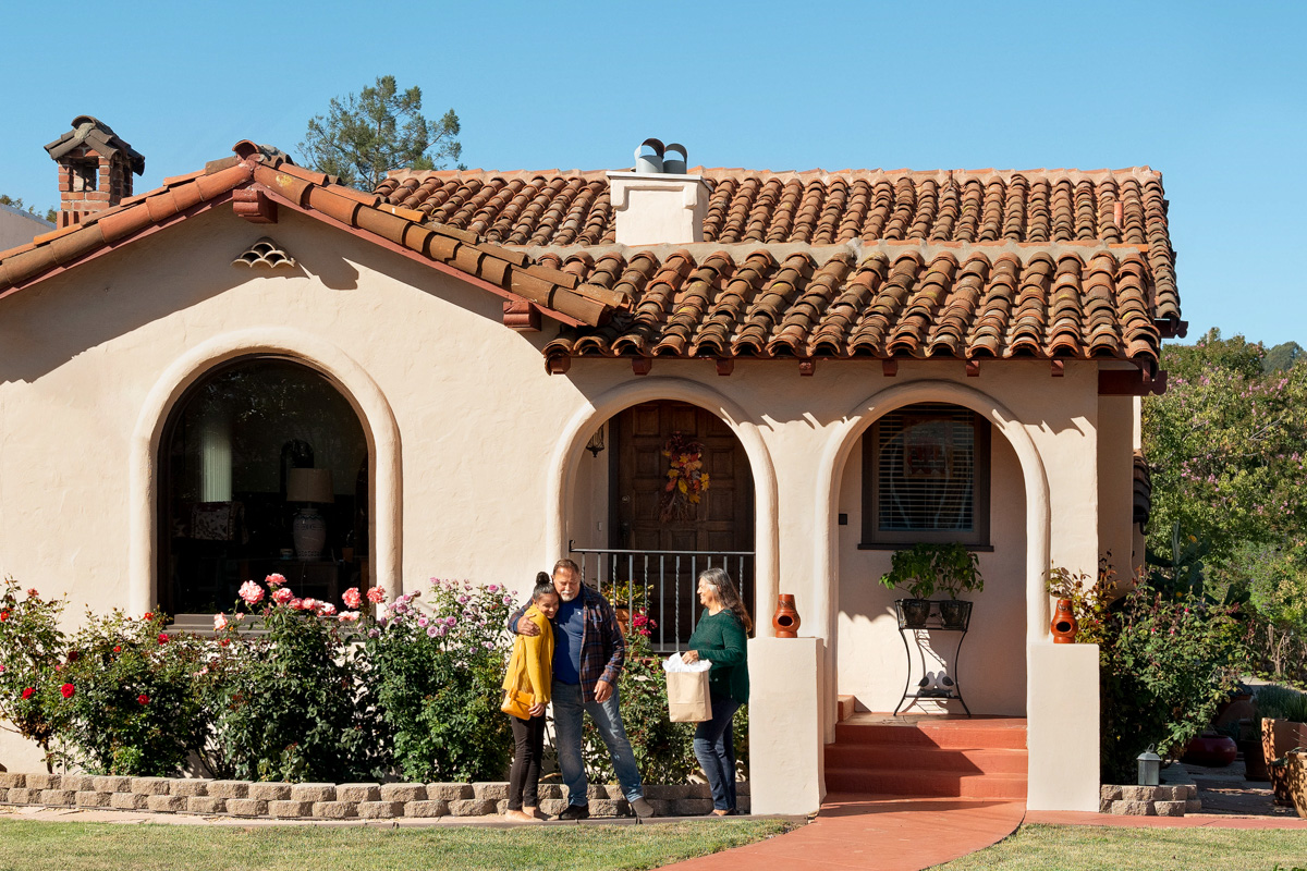 three people in front of a house