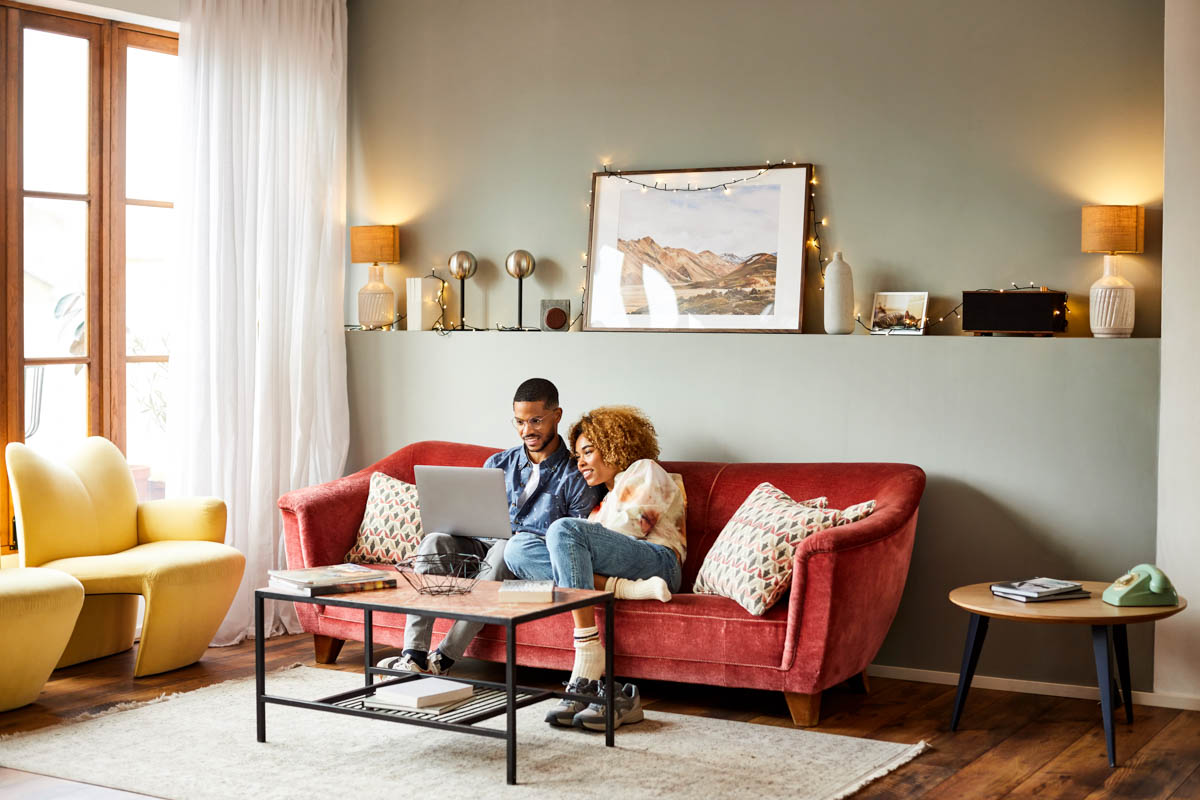 couple on couch on their laptop