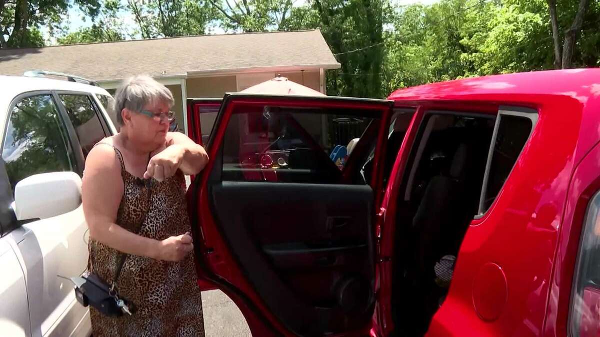 A woman looking into her car