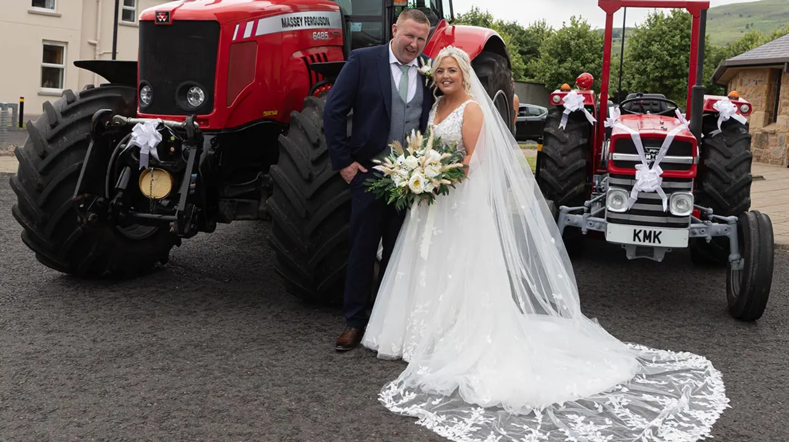 A married couple in front of tractors