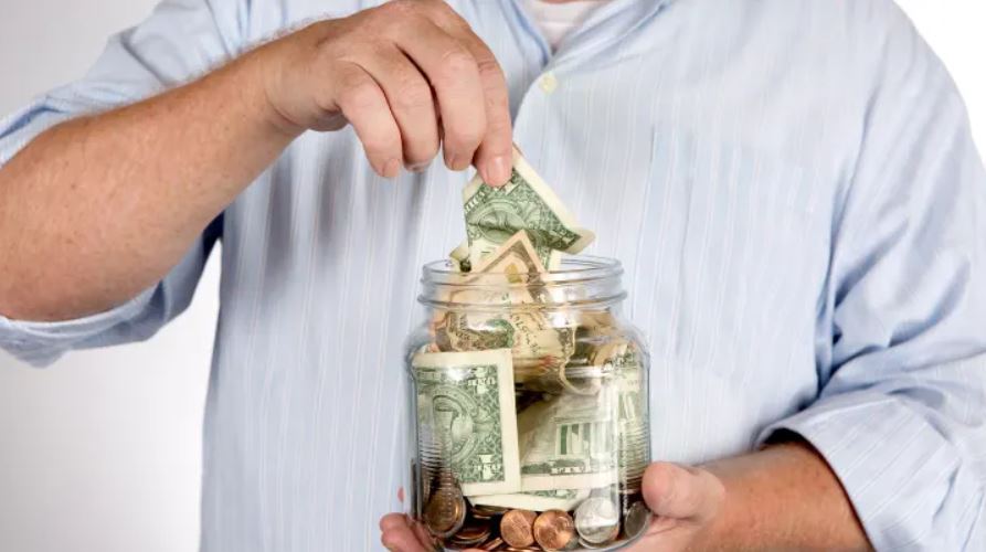 A person putting money in a jar