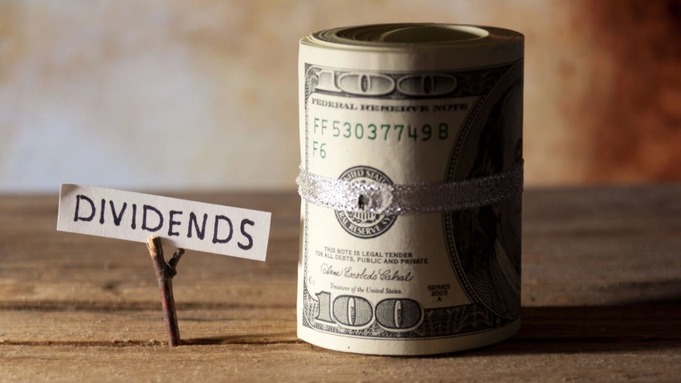 A dividends sign next to a roll of cash