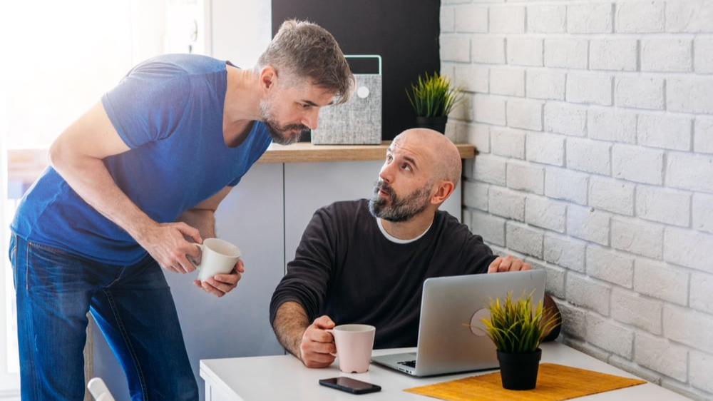 Two people discussing something on a laptop screen