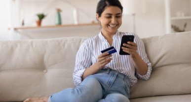 a woman on a couch shopping with her Amazon Prime Card