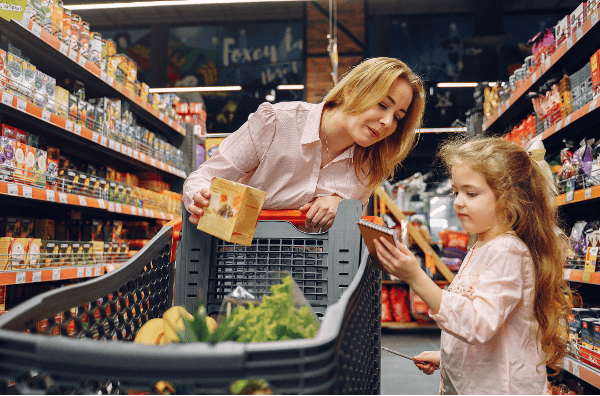 a woman and child grocery shopping with a budget