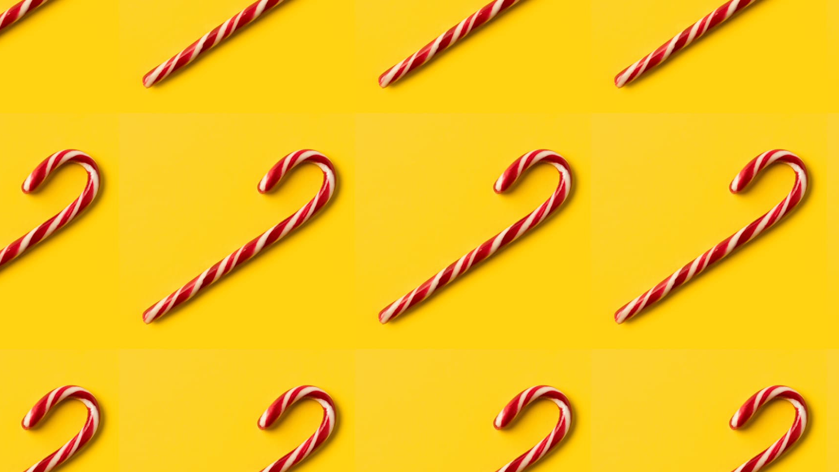 Rows of candy canes on a yellow background