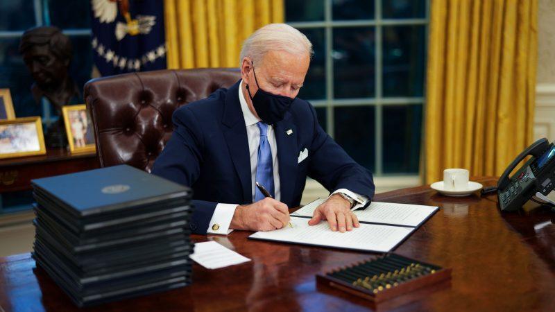 Biden singing a document