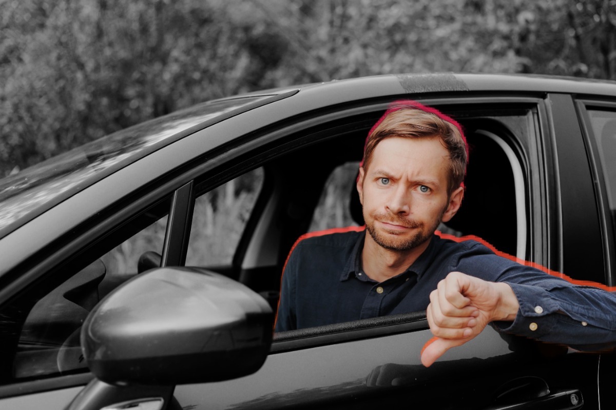 Man in a car giving a thumbs down