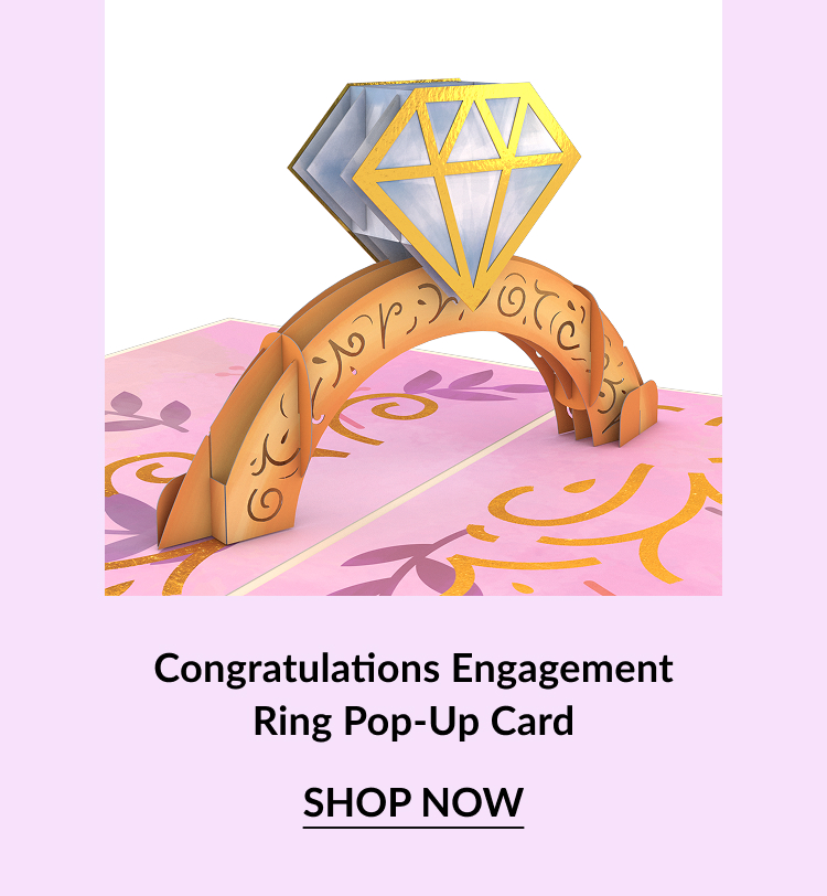 A pop-up card featuring a golden engagement ring and a diamond on a pink background, with ''Congratulations'' text.