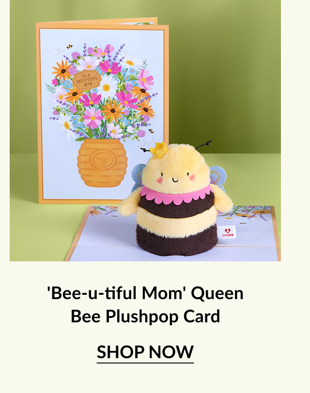 A cute bee plush toy in front of a colorful card that reads ''To a Bee-utiful Mom,'' featuring a vibrant floral design.