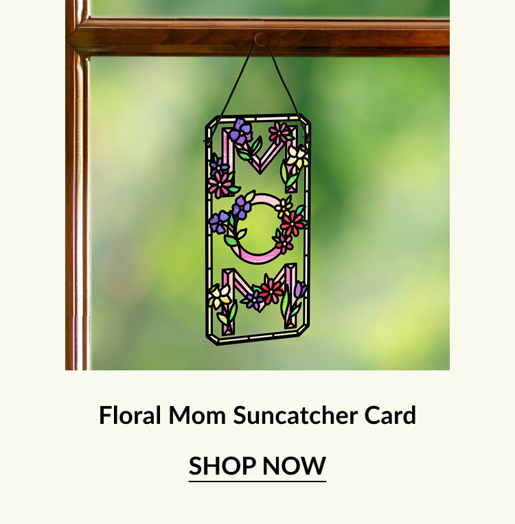 Colorful floral suncatcher card with ''MOM'' design hanging in a window, surrounded by greenery. Perfect for Mother's Day gifting.