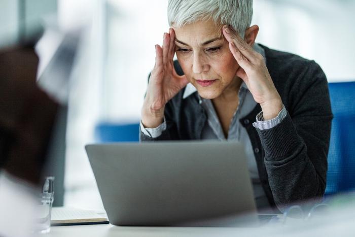 woman looking at her laptop, stressed about money. 