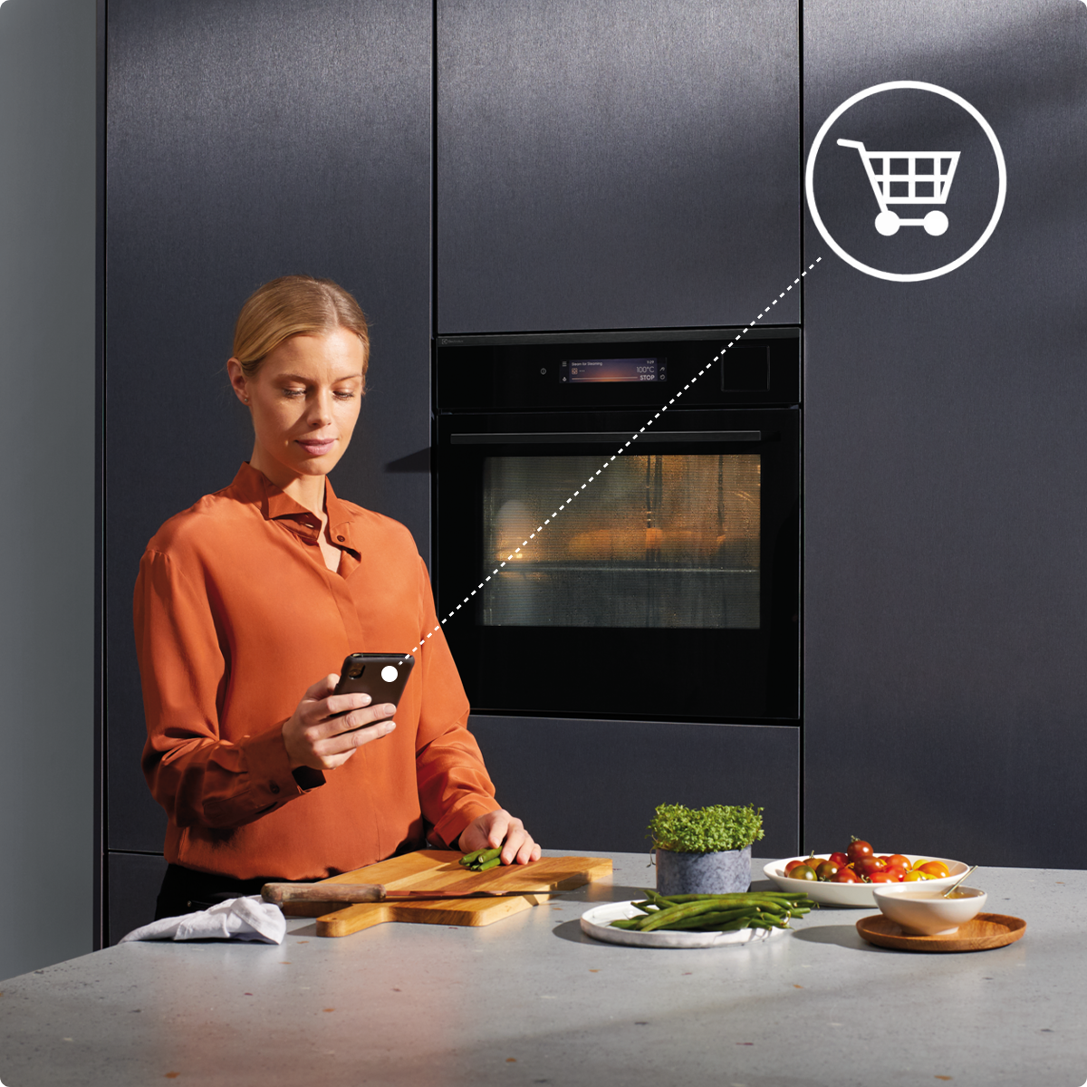 Kobieta w kuchni zamawia akcesoria do swojego piekarnika w aplikacji Electrolux