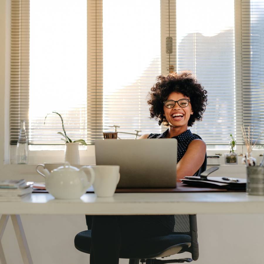 Woman smiling behind laptop