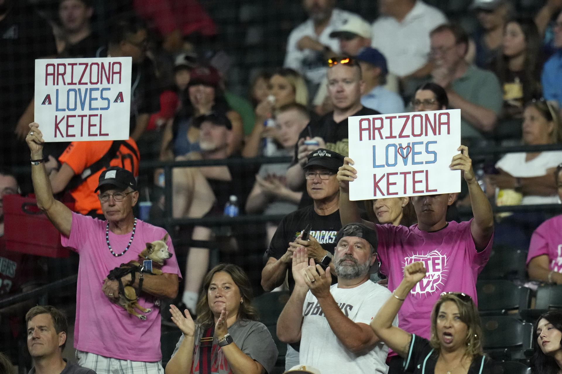 Fans hold signs supporting Ketel Marte