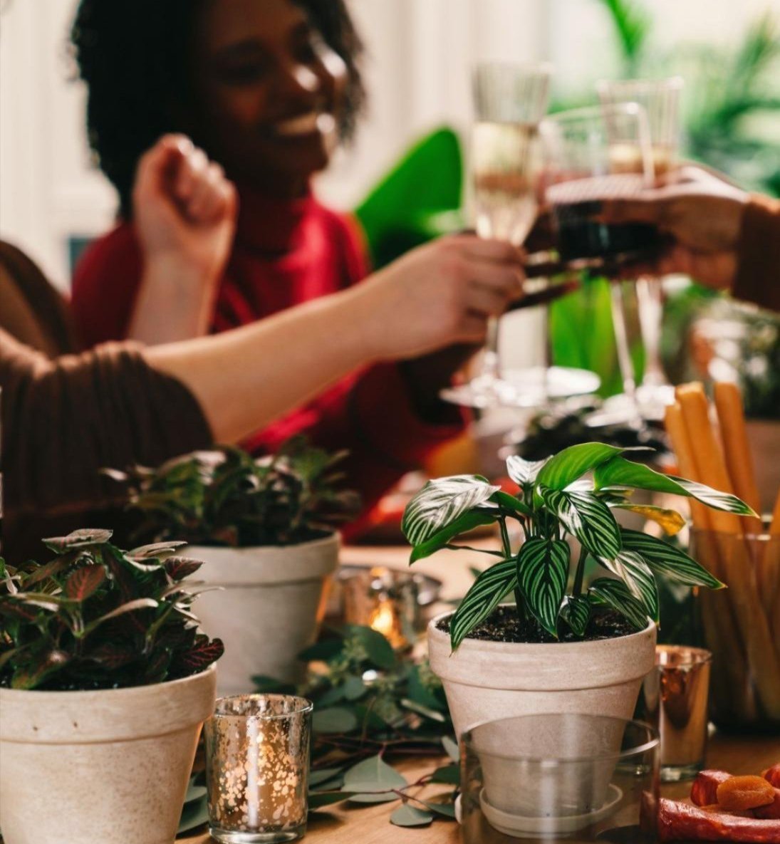 A holiday dinner table set with eucalyptus leaves and plants