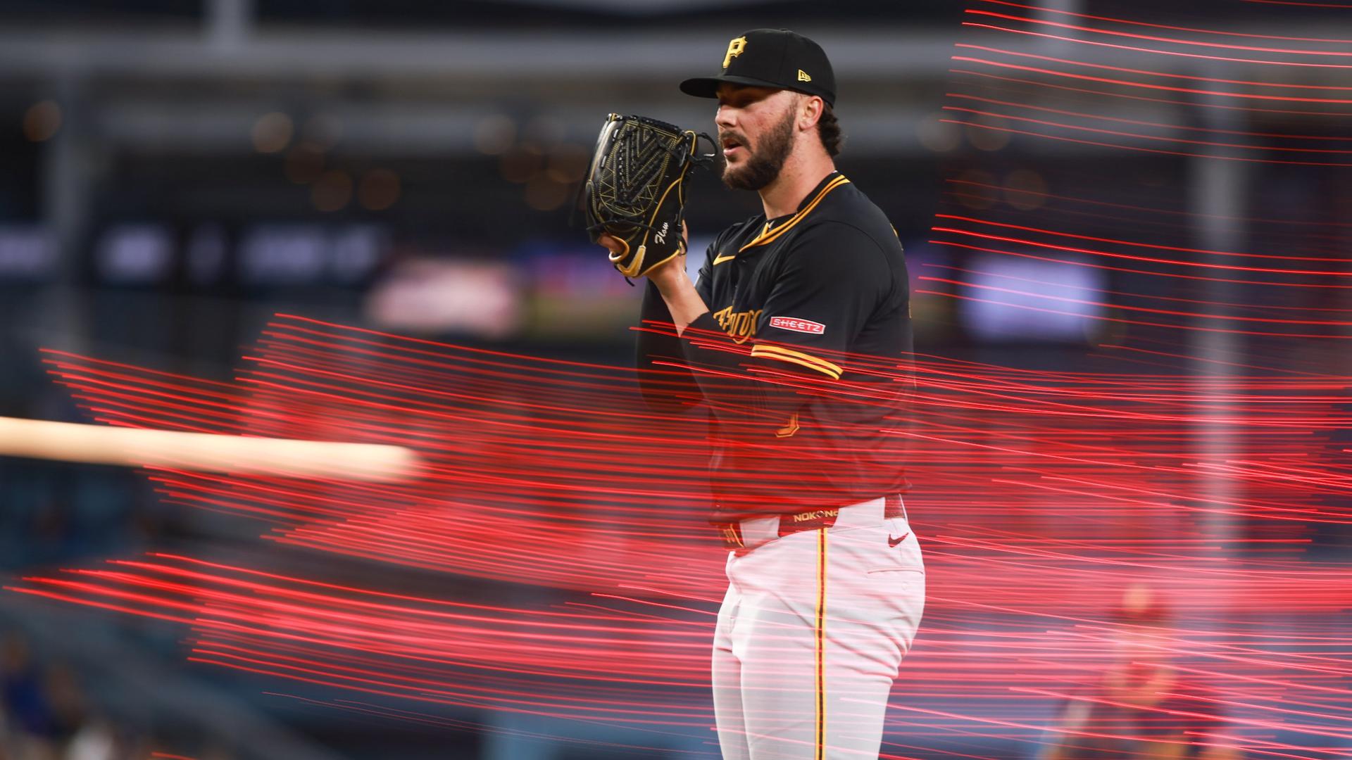 Paul Skenes on the mound basking in natural cool red light effect