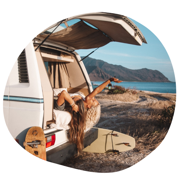 Two people laying outside of camper