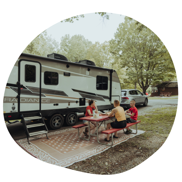 Friends sitting at picnic table outside of RV