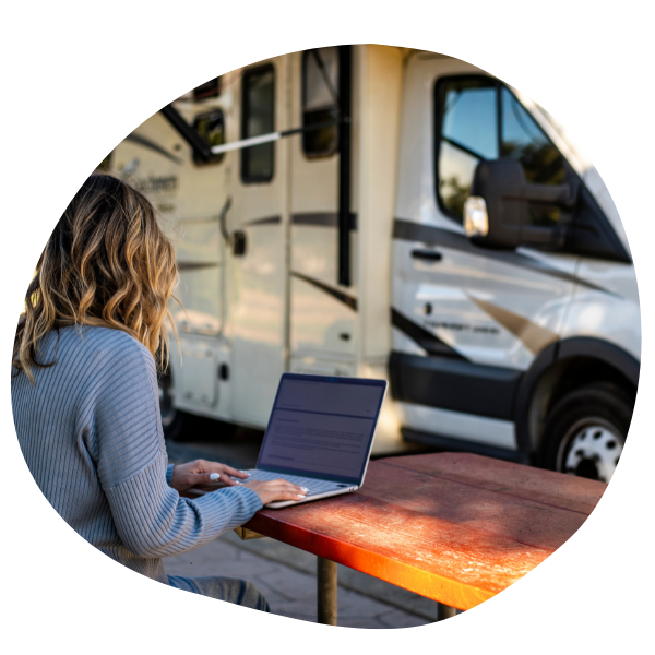 Person on laptop next to RV