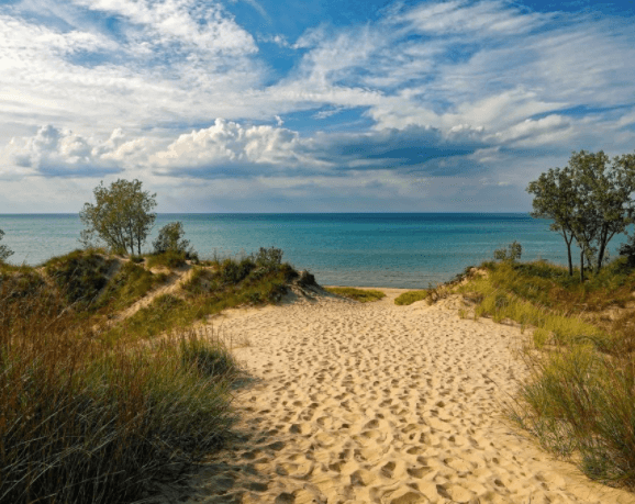Ocean view with white cloud filled sky and sand
