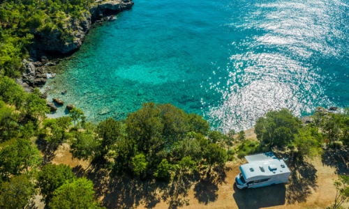 RV parked by the lake near woods