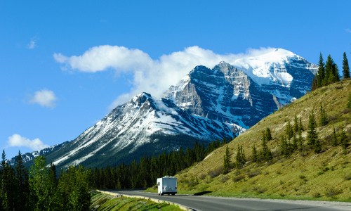 RV on the road driving towards mountains
