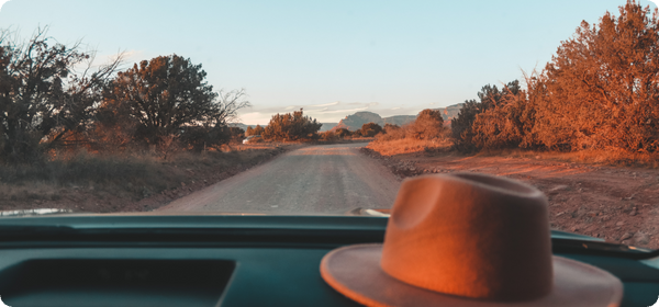RV with hat on dashboard on dirt road
