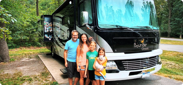 Dad with 3 kids in front of RV