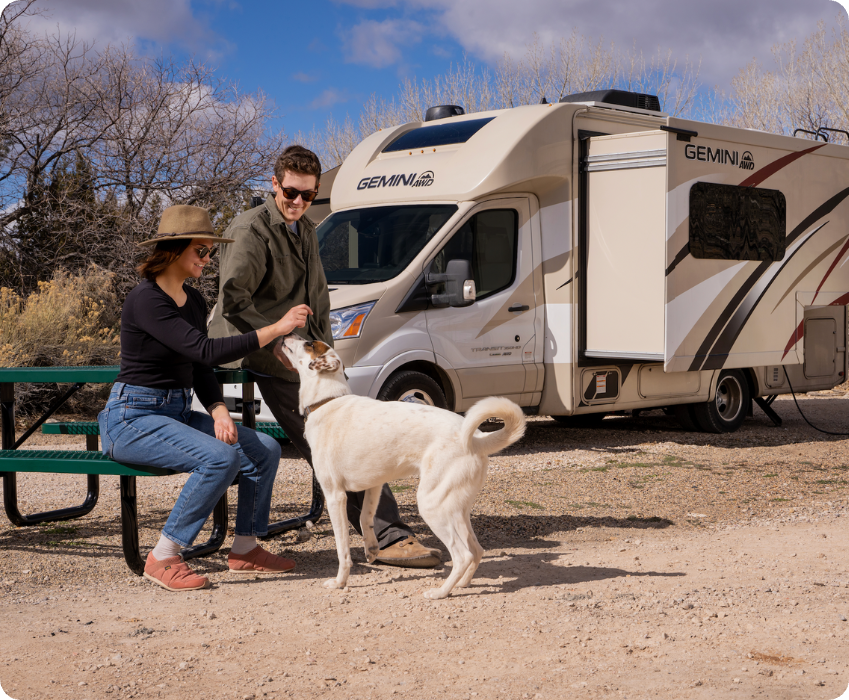 Couple petting dog outside of RV