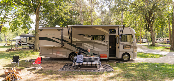 Older couple outside RV at picnic table