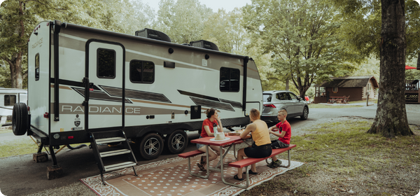 Family sitting outside RV