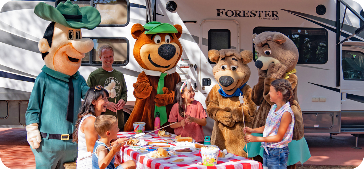 Friends eating outside of RV with Yogi and gang