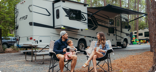Family sitting outside RV