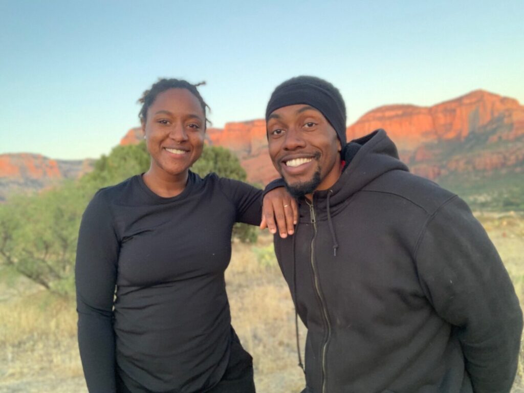 A couple smiling in front of desert mountain
