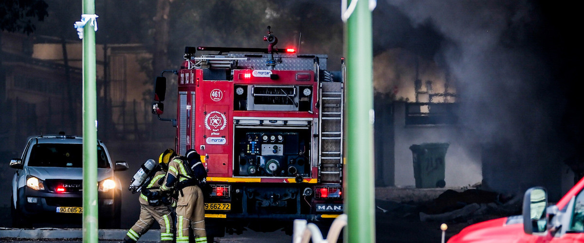 Firefighters work to extinguish a fire after a rocket fired from Lebanon hit the Israeli town of Shlomi.