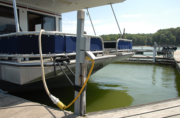 Pontoon boat has extension cord plugged in at dock