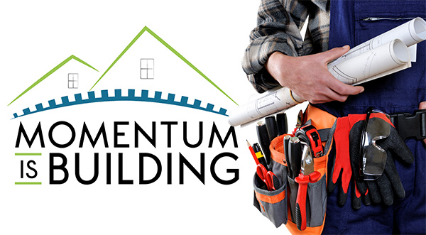 Momentum is Building - Photo: person wearing toolbelt holding blueprints.