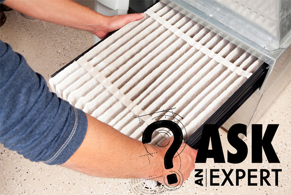 Ask an Expert - Photo: Hands replacing furnace filter.