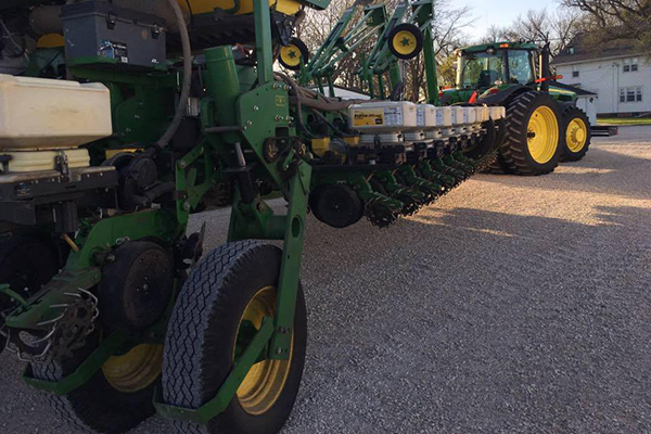 Big green tractor with planter attached ready for the field