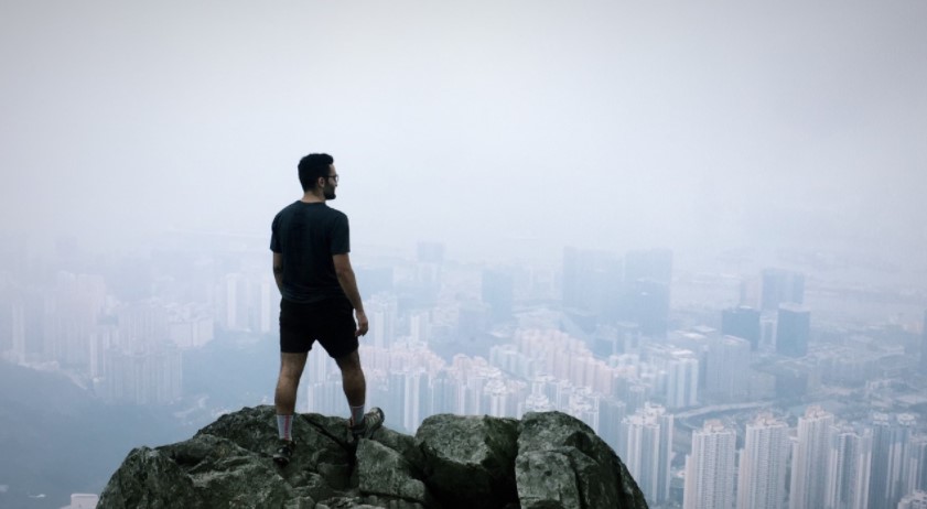 Man standing on mountain overlooking city