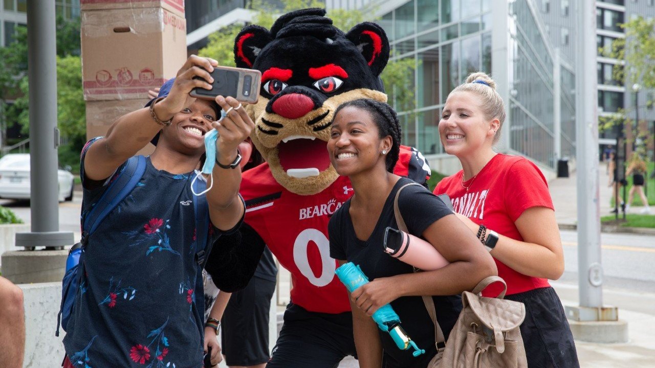 people smiling with the bearcat mascot