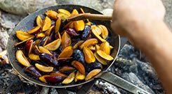 Nahaufnahme einer Bratpfanne mit Zwetschgenkompott über dem Feuer