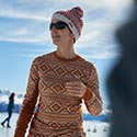 Eine Frau beim Schlittschuhfahren, sonniges Wetter und Berglandschaft im Hintergrund