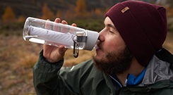 Wanderer trinkt Wasser aus einer Flasche