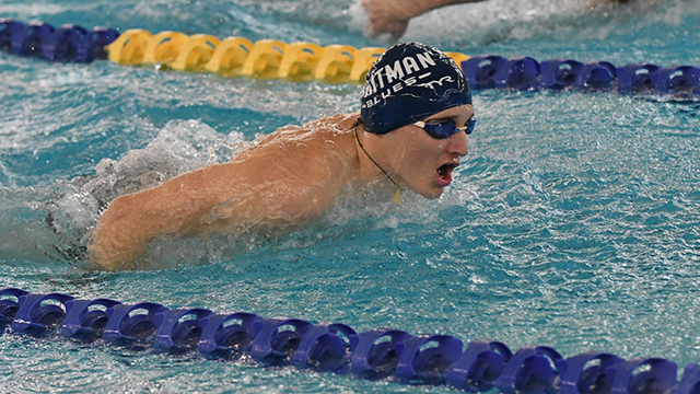 Ian McClelland, wearing a Blues swim cap and goggles lifts his head out of the water to take a breath while swimming.