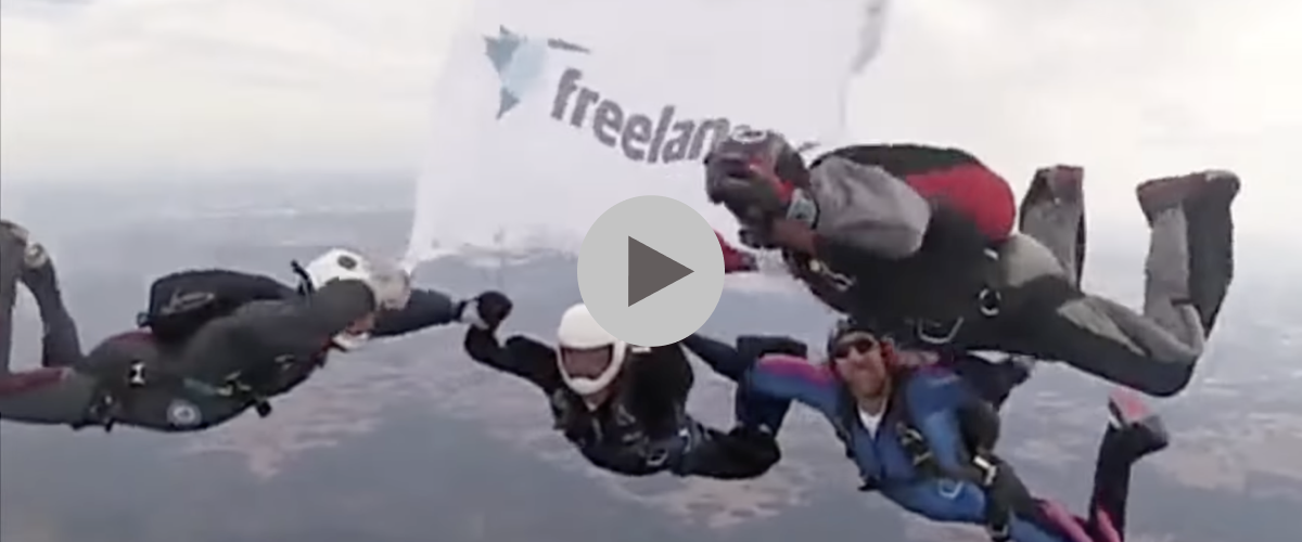 Group skydiving with Freelancer.com flag