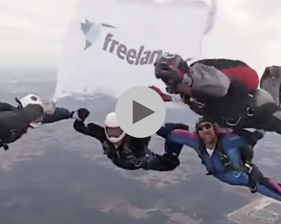 Group skydiving with Freelancer.com flag