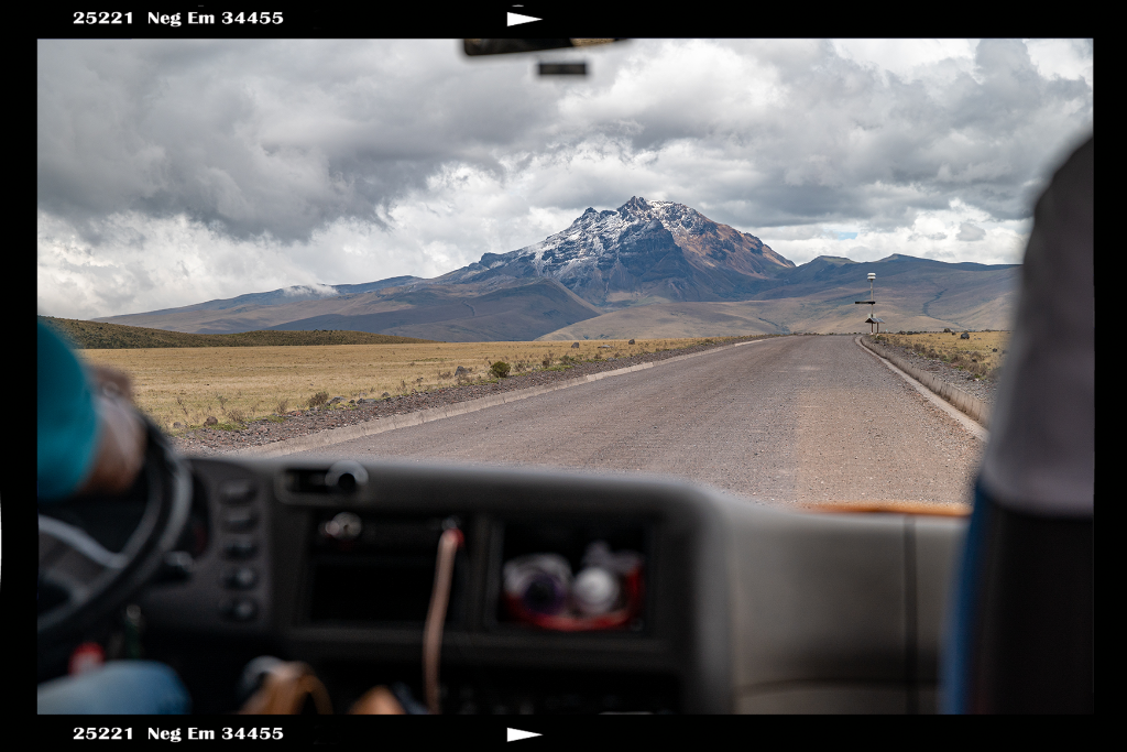 View of road leading to mountain with car dashboard in foreground.