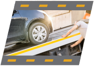 Tow truck driver pulling car onto truck bed